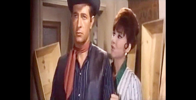 Vicky Lagos as saloon singer Sara, concerned about the health of Sheriff Sands (Julio Perez Tabernero as Anthony P. Taber) in a room full of coffins in Five Dollars for Ringo (1966)