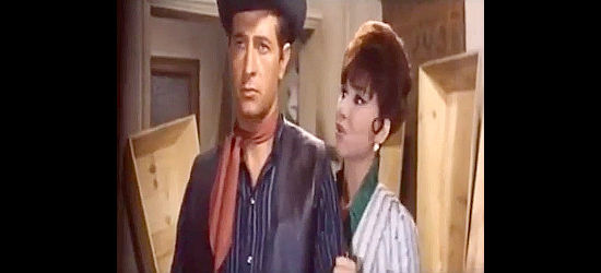 Vicky Lagos as saloon singer Sara, concerned about the health of Sheriff Sands (Julio Perez Tabernero as Anthony P. Taber) in a room full of coffins in Five Dollars for Ringo (1966)