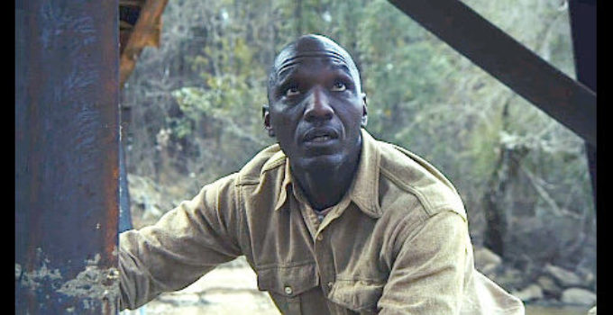 Cedric Burnside as Texas Red. anxiously watching a posse pass overhead in Texas Red (2021)
