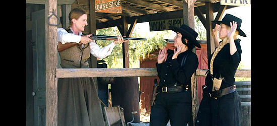 Diane Ouradnik as Katherine, holding two members of the Slim gang at bay with her shotgun in A Guide to Gunfighters of the Wild West (2021)
