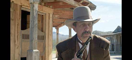 John Marrs as Sheriff Bob, the lawman who winds up with a prisoner and a woman holed up in his jail in She Was the Deputy's Wife (2021)