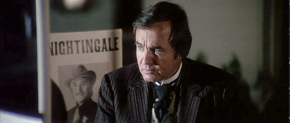 Mark Roberts as Cooper, the shopkeeper wondering about the whereabouts of his straying wife in Posse (1975)