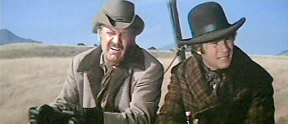 William Holden as Ross Bodine and Ryan O'Neal as Frank Post ride to town after a tragic accident on the ranch where they work in Wild Rovers (1971)