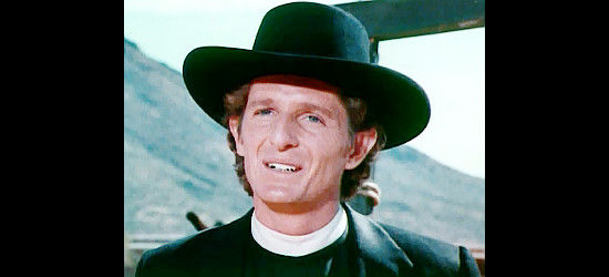 Marjoe Gortner as Ernie Parsons, impersonating Rev. Frank Fleming as he arrives in the town of Castle Walk in The Gun and the Pulpit