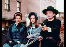 Marjoe Gortner as Ernie Parsons keeps two of Mr. Ross's men at bay while in the company of Sadie (Estelle Parsons) and Sally Underwood (Pamela Sue Martin) in The Gun and the Pulpit (1974)