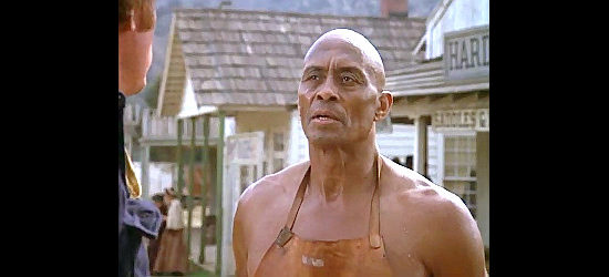 Woody Strode as Tucker, a blacksmith in a dispute with two customers in The Quest -- The Longest Drive (1976)