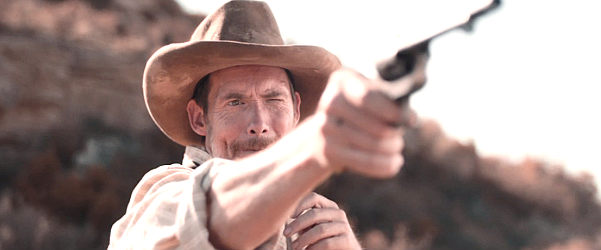 Morgan Symes as Reid Ryles, using a church bell for target practice in Gunight at Dry River (2021)