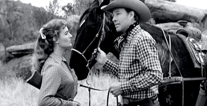Bill Elliott as Joe Daniels after Kay Collins (Peggy Stewart) comes to his defense in Kansas Territory (1952)