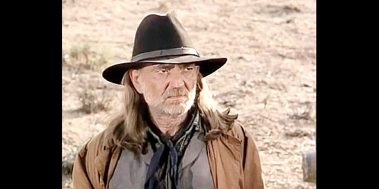 Willie Nelson as John Henry Lee, scowling when Cotton and his gang show up in Once Upon a Texas Train (1988)