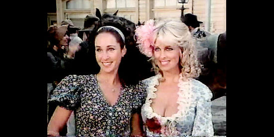 Pamela Bellwood as Sarah and Phyllis Davis as Sugar Harris, introducing themselves as friends to Sarah's surprised husband in The Wild Women of Chastity Gap (1983)