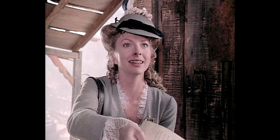 Robin McKee as Lindsey Thurlow, showing paperwork to prove she's supposed to marry one man, not six brothers, in Wagons East (1994)