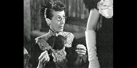 Virginia Slade as Meg, Henryetta's assistant, making adjustments to a party dress in Badman's Territory (1946)