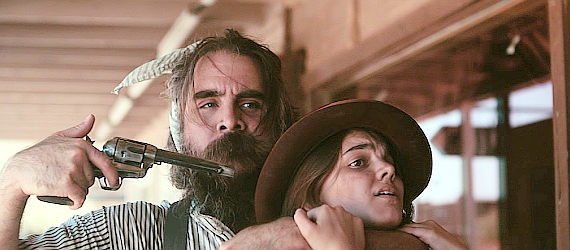 One of William Slade's henchmen threatening young saloon singer Maggie (Madilyn Mel) in Road to Revenge (2020)