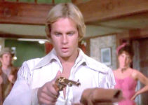 Jeff Osterhage as John Golden, admiring his new golden gun in The Legend of the Golden Gun (1979)