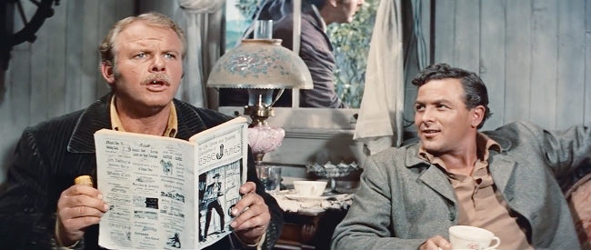 Alan Hale Jr. (left) as Cole Younger, reading about the exploits of Jesse in a dime novel in The True Story of Jesse James (1957)