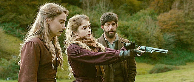 Alice Isaaz as Esther, showing Abigaelle (Maryne Bertieaux) and Samuel (Pierre Yves Cardinal) that's she's not bashful about using a pistol in Savage State (2019)
