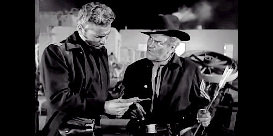 Jay C. Flippen as Sgt. Terrance Duey, showing Maj. Kenniston a message from the Indians in Two Flags West (1950)
