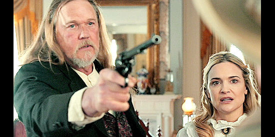 Trace Adkins as Thorn Larson confronts an intruder while Carol Cassidy (Victoria Pratt) looks on in The Desperate Riders (2022)