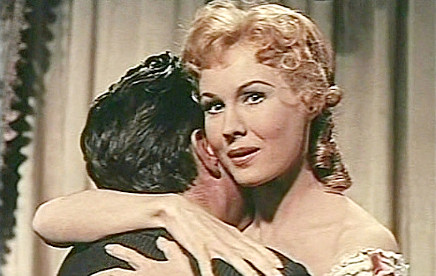 Virgina Mayo as Helen Jagger, hugging her brother and about to meet his business partner in The Big Land (1957)