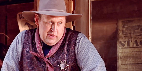 David Hart as Bob Logan, the Fairplay sheriff wary of newcomer Kincaid in Forgiven (2011)