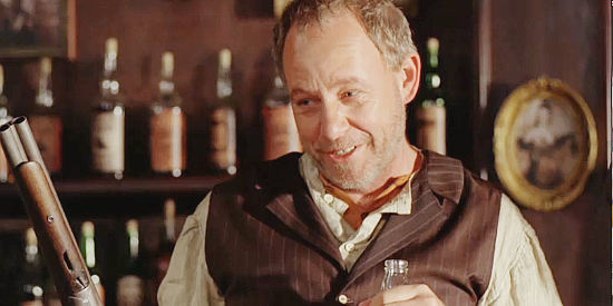 Brad Greenquist as Garrett, the barkeep, with a shotgun in one hand and a drink in the other in Copperhead (2008)