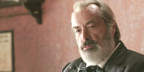 Powers Boothe as Judge Valentine Hatfield, presiding over a trial about a pig in Hatfields & McCoys (2012)