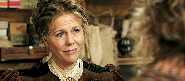 Rita Wilson as Carolyn, the friendly storekeeper Margaret Dutton meets at Doan's Crossing in 1883 (2021-22)