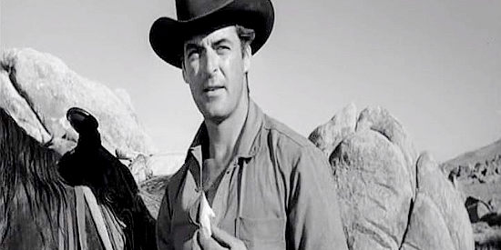 Rory Calhoun as Gil McCord, with the stone he uses to make his horse appear lame in The Hired Gun (1957)