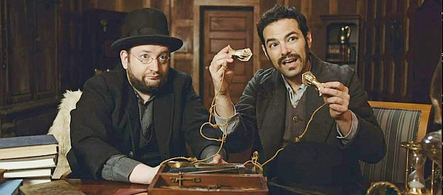 Jamie Elman (right) as Eliezer and his partner trying to sell Enoch a male rejuvenation device in Bordello (2023)