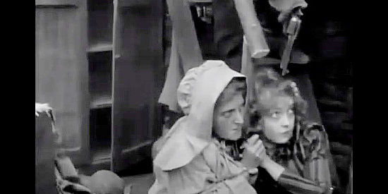 Lillian Gish as Melissa Harlow, huddled with a friend as the battle rages outside, a gun at her head in case the Indians break through in The Battle of Elderbush Gulch (1913)