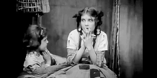 Mae Marsh as Sally Cameron and her younger sister worry about puppies left outside the ranch house in The Battle of Elderbush Gulch (1913) 