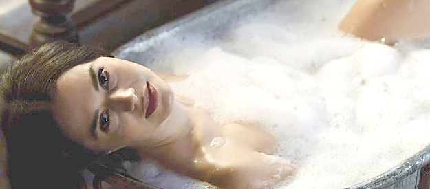 Nisa Gunduz as Esi, teasing her boss Enoch as she bathes in Bordello (2023)