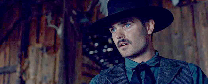 Alex Roe as Pat Garrett, a member of the 7 Rivers Gang, becoming acquainted with Billy in Billy the Kid (2022)