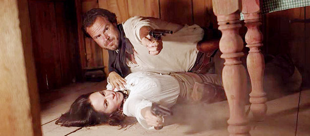 Beau Yotty as William Cole and Lisa Barnes as Belle MacLure, defending themselves in an unusual position in For the Reward (2022)