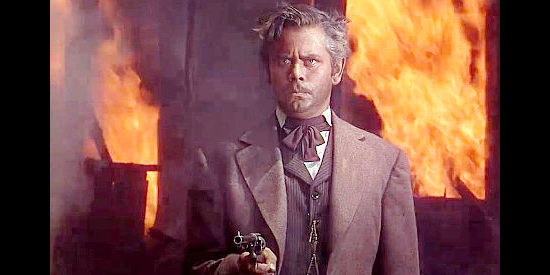 Glenn Ford as Judge Owen Devereaux, ready for a showdown as an inferno rages behind him in The Man from Colorado (1948)