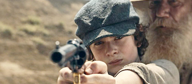 Joanh Collier as young Billy, getting his first shooting lesson from Moss (Timothy Webber) in Billy the Kid (2022)