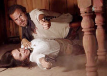 Beau Yotty as William Cole and Lisa Barnes as Belle MacLure, defending themselves in an unusual position in For the Reward (2022)