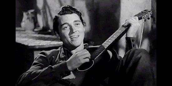 William Bishop as The Kid, entertaining his companions with a song in Thunderhoof (1948)