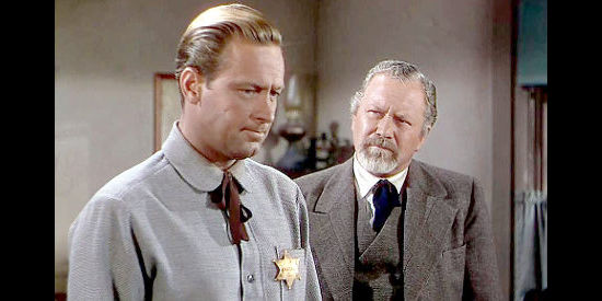 William Holden as Del Stewart, expressing concerns about Owen's mental state to Doc Merriam (Edgar Buchanan) in The Man from Colorado (1948)