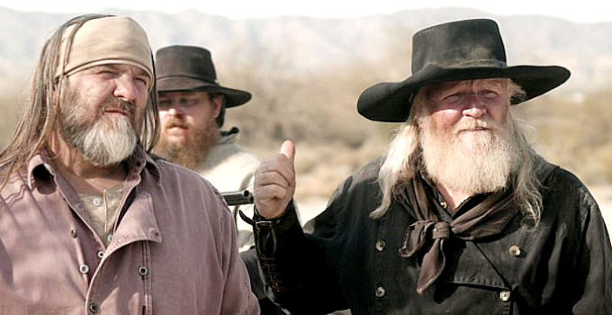 Russell Clay as the Waco Kid and George Nelson as Dutch Langford, proposing a prize fight as a way out of a jam in Bite the Dust (2023)