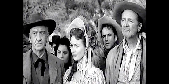 John Litel as Morgan Wheeler and Coleen Gray as Sue 'Lucky' Duneen, listening to Aaron Baring's orders to keep the wagon train moving in The Wild Dakotas (1956)