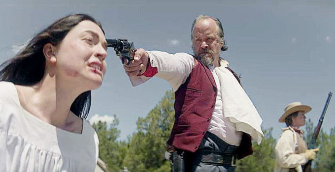 Andrew E. Wheeler as Shaw with a gun on Hildegard (Tiffany Cornwell) in Sanctified (2022)