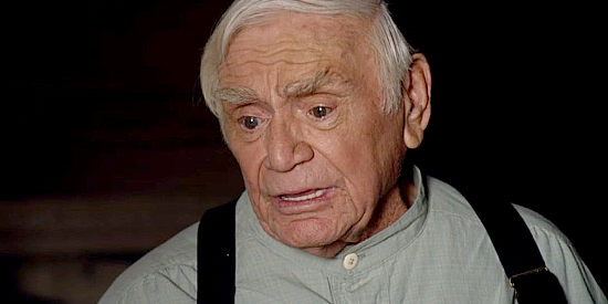 Ernest Borgnine as Nicholaus, nursing Aaron Davis back to health after he's wounded by a thief in Love's Christmas Journey (2011)
