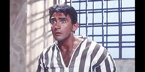 Walter Chiari as Pablo, confronted with an unwelcome visitor in his prison cell in The Magnificent Three (1961)