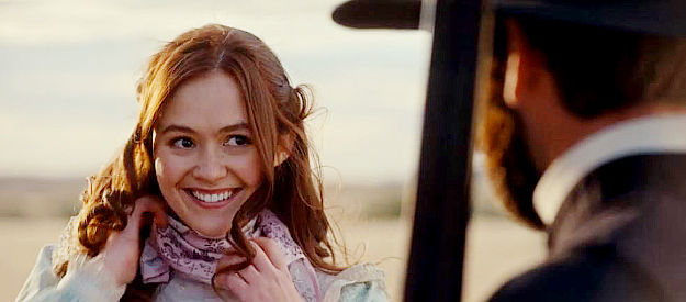 Olivia Sanabia as Hope Jacobs, trying on a scarf, a gift from her father, in Birthright Outlaw (2023)
