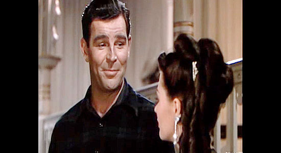 Rod Cameron as Dan Corrigan, discussing what he expects from a wife with Sequin in River Lady (1948)