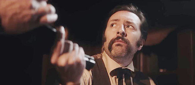 Michael Fredianelli as Wesley Hart, passing a six-gun to his deputy as they head out to investigate a reported murder in The Perfect Hand (2023)