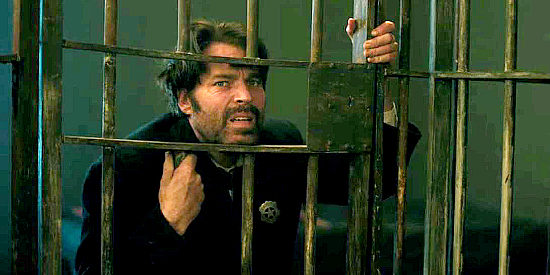 Tim Roxon as Sheriff Mason, finding himself confined in one of his own jail cells in Calamity Jane (2024)