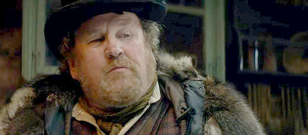 Colm Meaney as Caleb, caculating how much restitution he's owed by the Crockett boys in The Ballad of Davy Crockett (2024)