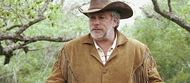 Craig Rainey as Walker, about to be asked to show off his shooting skills in The Oldest Posse (2023)